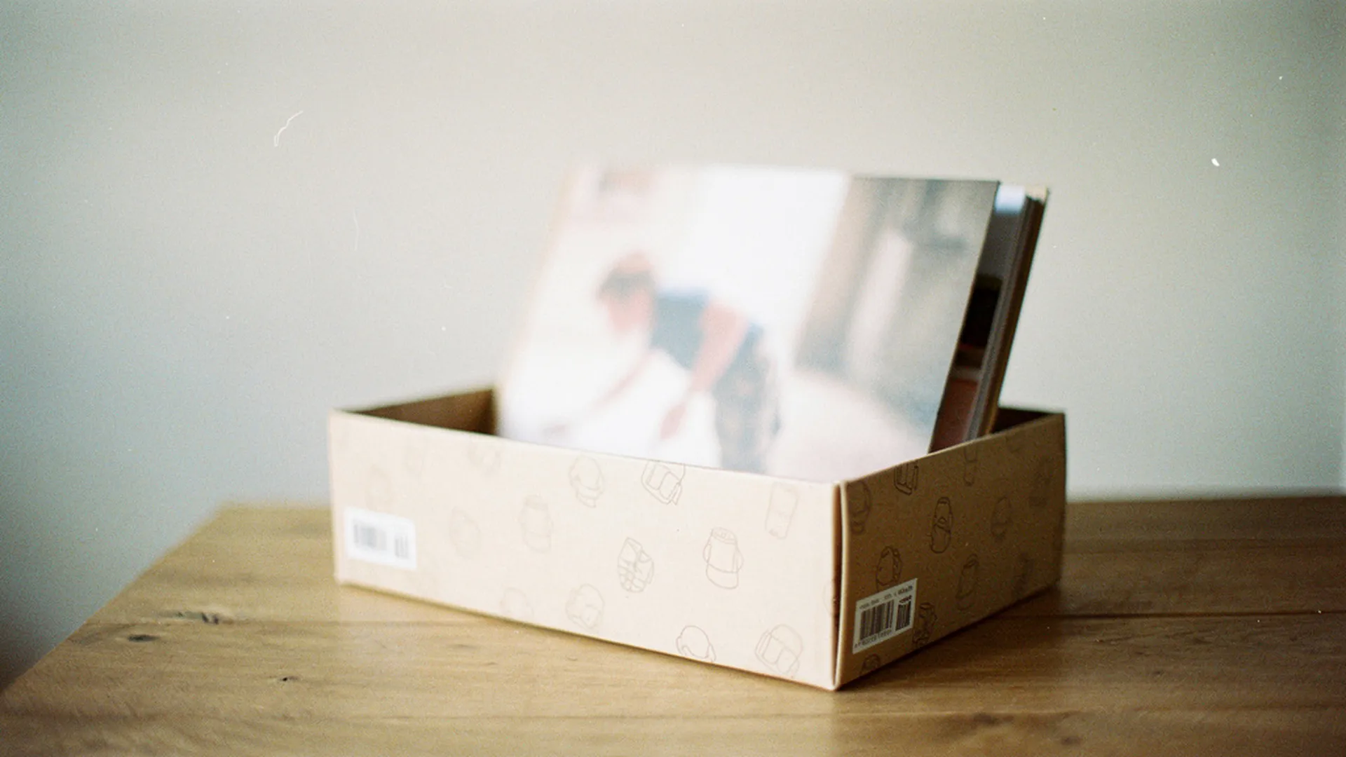 Livre personnalisé pour enfant posé dans une boîte cadeau décorée, sur une table en bois