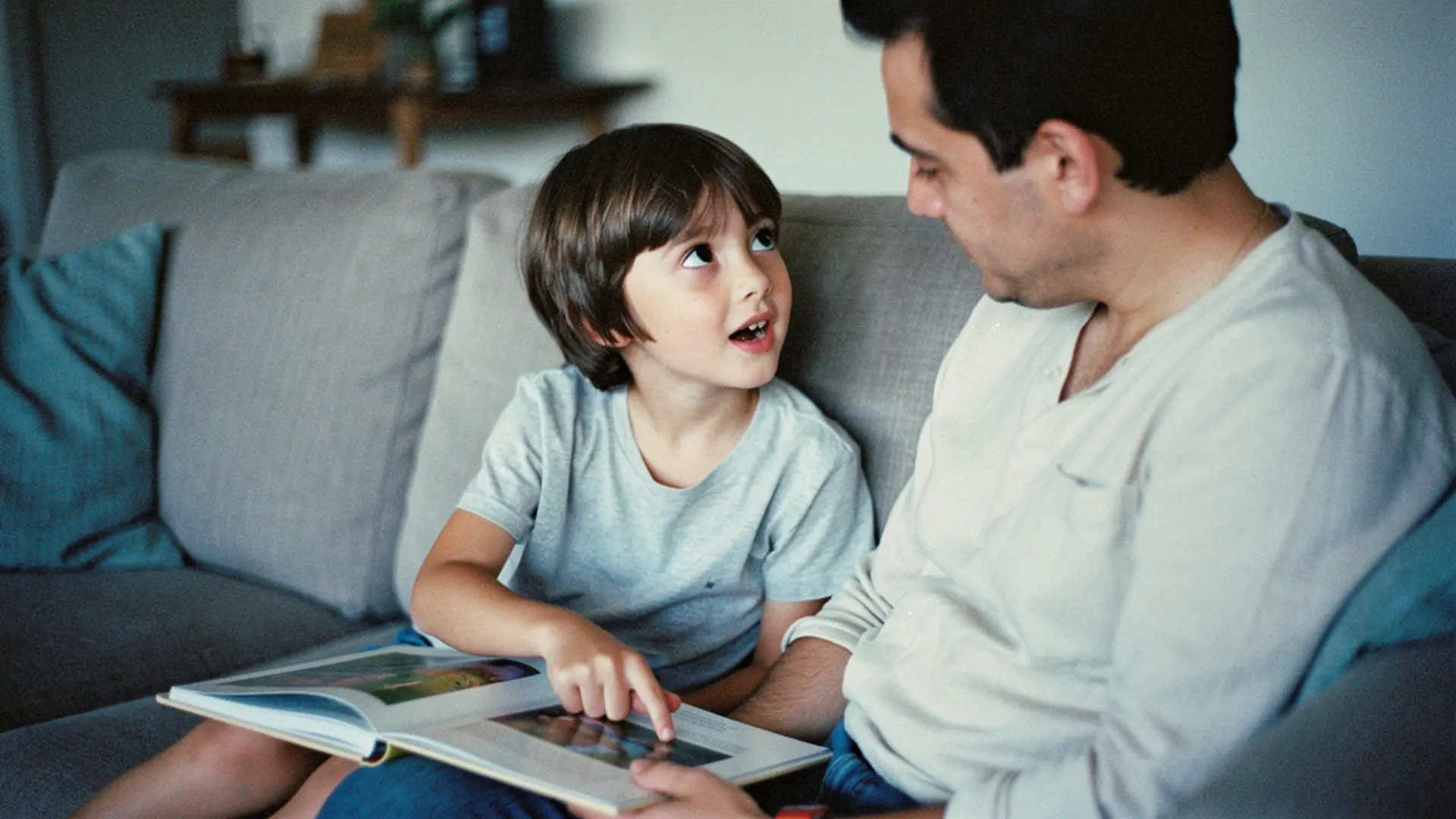 Enfant de 6 ans posant une question à son parent pendant la lecture d'un livre, le soir