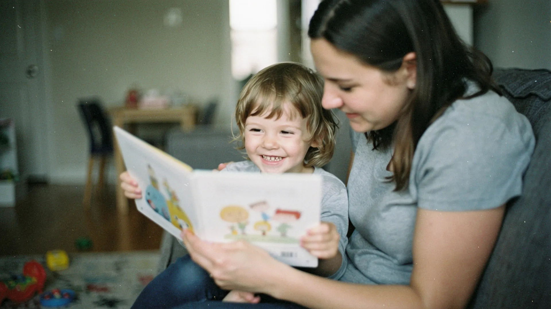 Enfant de 4 ans souriant, montrant une page illustrée d'un livre à sa mère