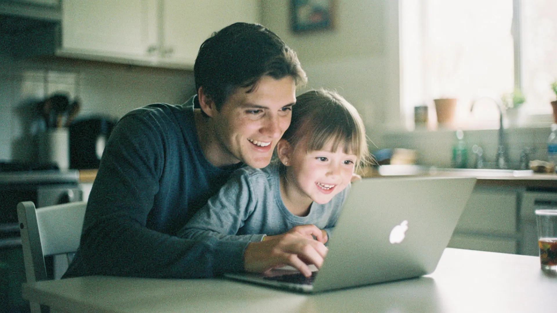 Parent et enfant de 4 ans choisissant ensemble un livre devant un ordinateur