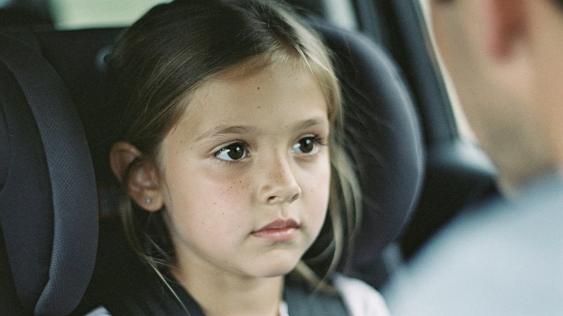 Gros plan sur le visage calme d'une petite fille assise dans un siège auto après un rendez-vous médical